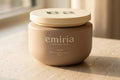 Jar of emiria Command Cream on a light surface with a blurred background