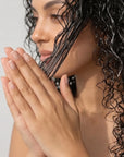 Woman with wet, styled hair against a plain background